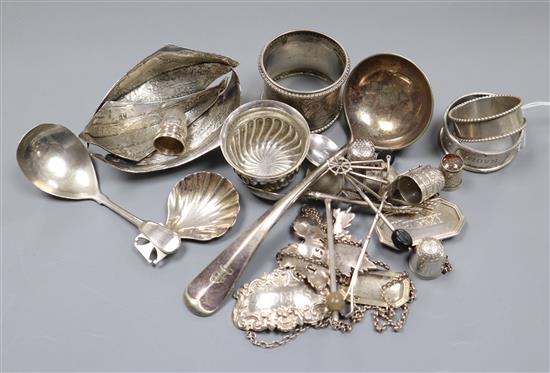 A group of assorted small silver and plated items including caddy spoons, napkin rings, thimbles, wine labels etc.